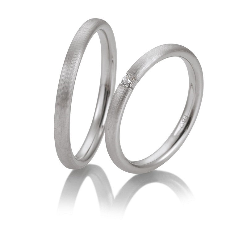 Breuning vielsesringe i 9-14 kt hvidguld med blank overflade og 0,04 ct brillant i dameringen.