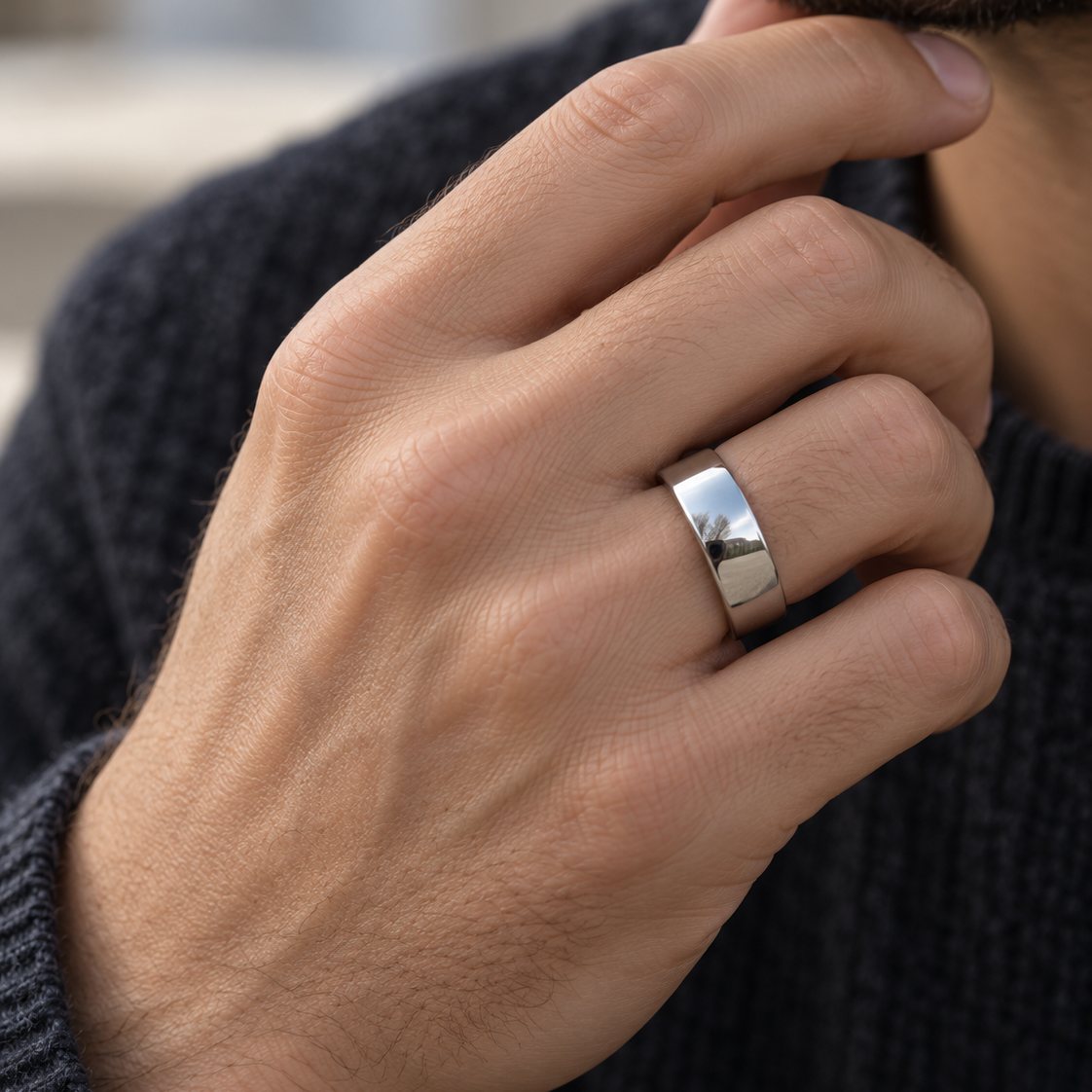 Mann trägt den glatten Rico's Ring aus Stahl am Ringfinger, die Hand am Kinn