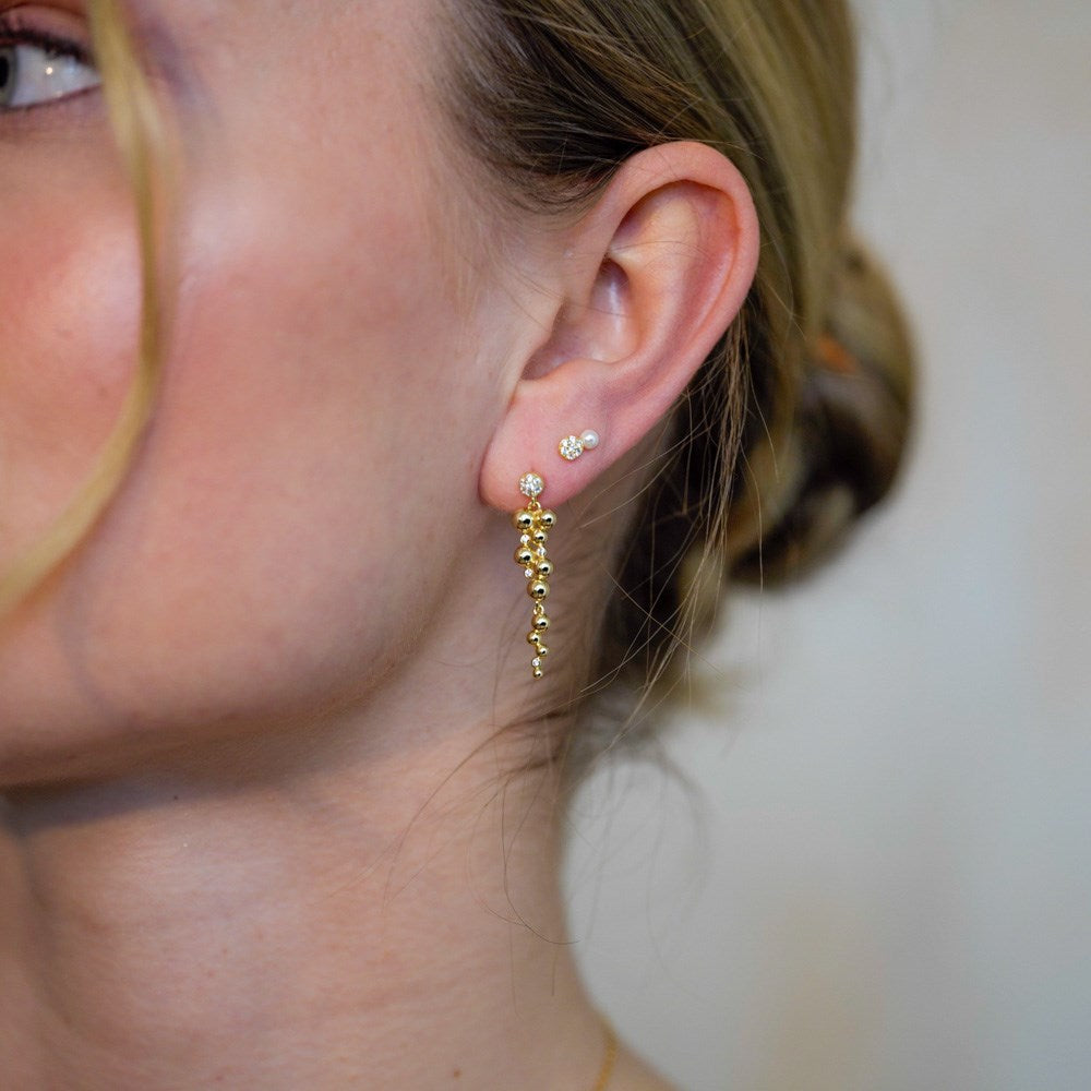Joanli Nor TiaNor Ohrringe mit weißer Perle und funkelnden Zirkonia aus vergoldetem 925er Sterlingsilber, elegant am Model präsentiert